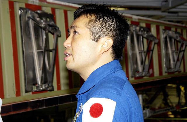 NASA image: KENNEDY SPACE CENTER, FLA. - Japanese astronaut Koichi Wakata looks at the spars installed on the wing of the orbiter Atlantis.  Reinforced Carbon Carbon (RCC) panels are mechanically attached to the wing via the spars - a series of floating joints - to reduce loading on the panels caused by wing deflections. The aluminum and the metallic attachments are protected from exceeding temperature limits by internal insulation.