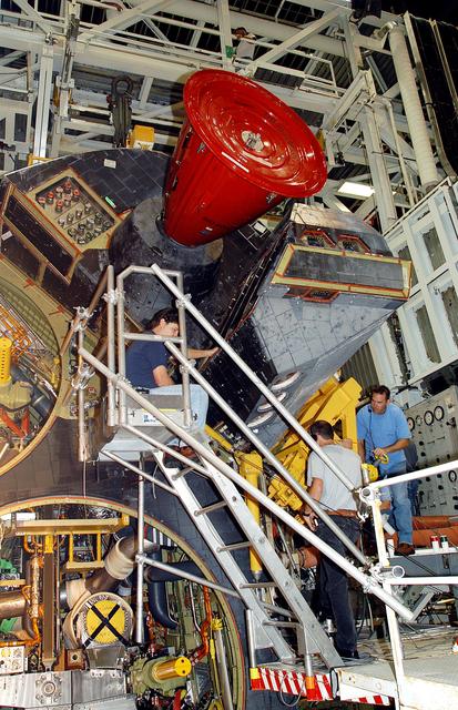 NASA image: KENNEDY SPACE CENTER, FLA. -  Workers in the Orbiter Processing Facility prepare to  remove one of two orbital maneuvering system (OMS) pods from Endeavour.  The OMS pods are attached to the upper aft fuselage left and right sides.  Fabricated primarily of graphite epoxy composite and aluminum, each pod is 21.8 feet long and 11.37 feet wide at its aft end and 8.41 feet wide at its forward end, with a surface area of approximately 435 square feet. Each pod houses the Reaction Control System propulsion components used for inflight maneuvering and is attached to the aft fuselage with 11 bolts.   OMS pods are removed during Orbiter Major Modifications. Once removed, the OMS pods undergo in-depth structural inspections, system checks and the thrusters are changed out.