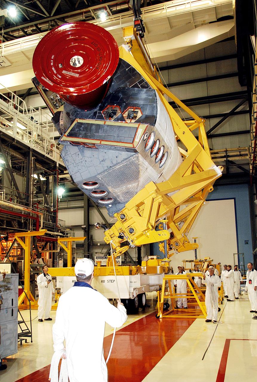 KENNEDY SPACE CENTER, FLA. - In the Orbiter Processing Facility, one of two orbital maneuvering system (OMS) pods removed from Endeavour is lowered toward a transporter. The OMS pods are attached to the upper aft fuselage left and right sides. Fabricated primarily of graphite epoxy composite and aluminum, each pod is 21.8 feet long and 11.37 feet wide at its aft end and 8.41 feet wide at its forward end, with a surface area of approximately 435 square feet. Each pod houses the Reaction Control System propulsion components used for inflight maneuvering and is attached to the aft fuselage with 11 bolts. OMS pods are removed during Orbiter Major Modifications. Once removed, the OMS pods undergo in-depth structural inspections, system checks and the thrusters are changed out.