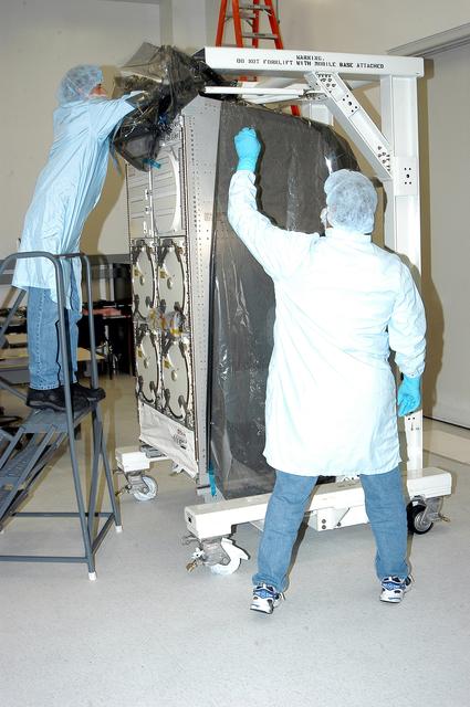 NASA image: KENNEDY SPACE CENTER, FLA. -  In the Space Station Processing Facility, technicians remove the cover from the Minus Eighty Lab Freezer for ISS(MELFI) provided as Laboratory Support Equipment by the European Space Agency for the International Space Station.  The lab will provide cooling and storage for reagents, samples and perishable materials in four insulated containers called dewars with independently selectable temperatures of -80°C, -26°C, and +4°C. It also will be used to transport samples to and from the station.   The MELFI is planned for launch on the ULF-1 mission.