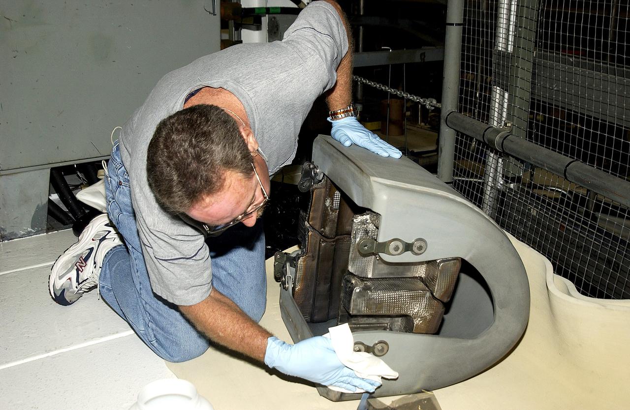 KENNEDY SPACE CENTER, FLA. -  In the Orbiter Processing Facility, United Space Alliance worker Mike Hyatt looks over a Reinforced Carbon Carbon (RCC) panel that will be attached to the leading edge of the wing of the orbiter Atlantis.  The gray carbon composite RCC panels have sufficient strength to withstand the aerodynamic forces experienced during launch and reentry, which can reach as high as 800 pounds per square foot.  The operating range of RCC is from minus 250º F to about 3,000º F, the temperature produced by friction with the atmosphere during reentry.