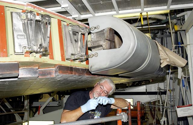 NASA image: KENNEDY SPACE CENTER, FLA. -   Billy Witt, a midbody shop mechanic with United Space Alliance, checks a part used for installation of a Reinforced Carbon Carbon (RCC) panel to the leading edge of the wing of an orbiter.  Above him is an RCC panel just installed on Atlantis.  The gray carbon composite RCC panels have sufficient strength to withstand the aerodynamic forces experienced during launch and reentry, which can reach as high as 800 pounds per square foot.  The operating range of RCC is from minus 250º F to about 3,000º F, the temperature produced by friction with the atmosphere during reentry.