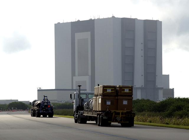 NASA image: KENNEDY SPACE CENTER, FLA. -  Flatbed trucks carrying some of the debris of Space Shuttle Columbia approach the Vehicle Assembly Building (VAB).  The debris is being transferred from the Columbia Debris Hangar to the VAB for permanent storage.  More than 83,000 pieces of debris were shipped to KSC during search and recovery efforts in East Texas. That represents about 38 percent of the dry weight of Columbia, equaling almost 85,000 pounds.