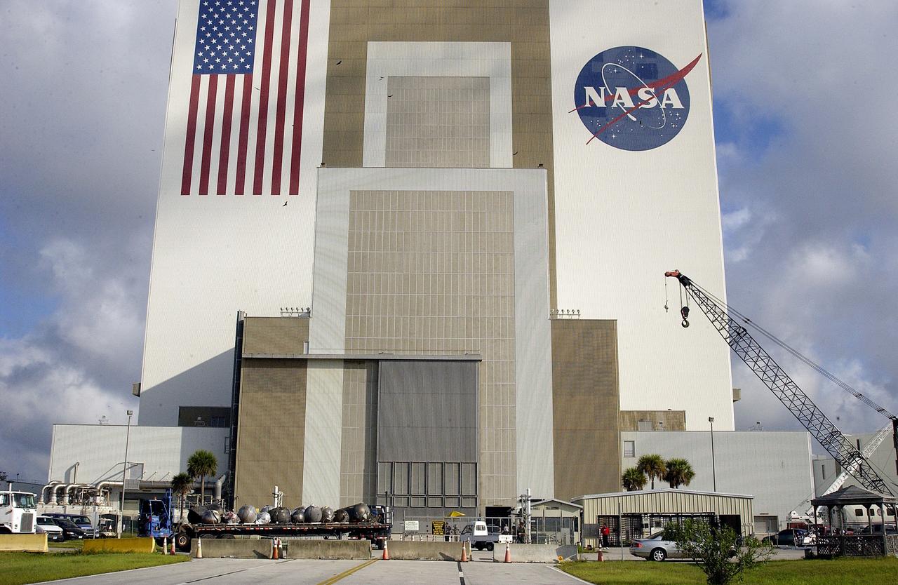 KENNEDY SPACE CENTER, FLA. -  A flatbed truck carrying pieces of debris of Space Shuttle Columbia arrives outside the Vehicle Assembly Building (VAB).  The debris is being transferred from the Columbia Debris Hangar to the VAB for permanent storage.  More than 83,000 pieces of debris were shipped to KSC during search and recovery efforts in East Texas. That represents about 38 percent of the dry weight of Columbia, equaling almost 85,000 pounds.