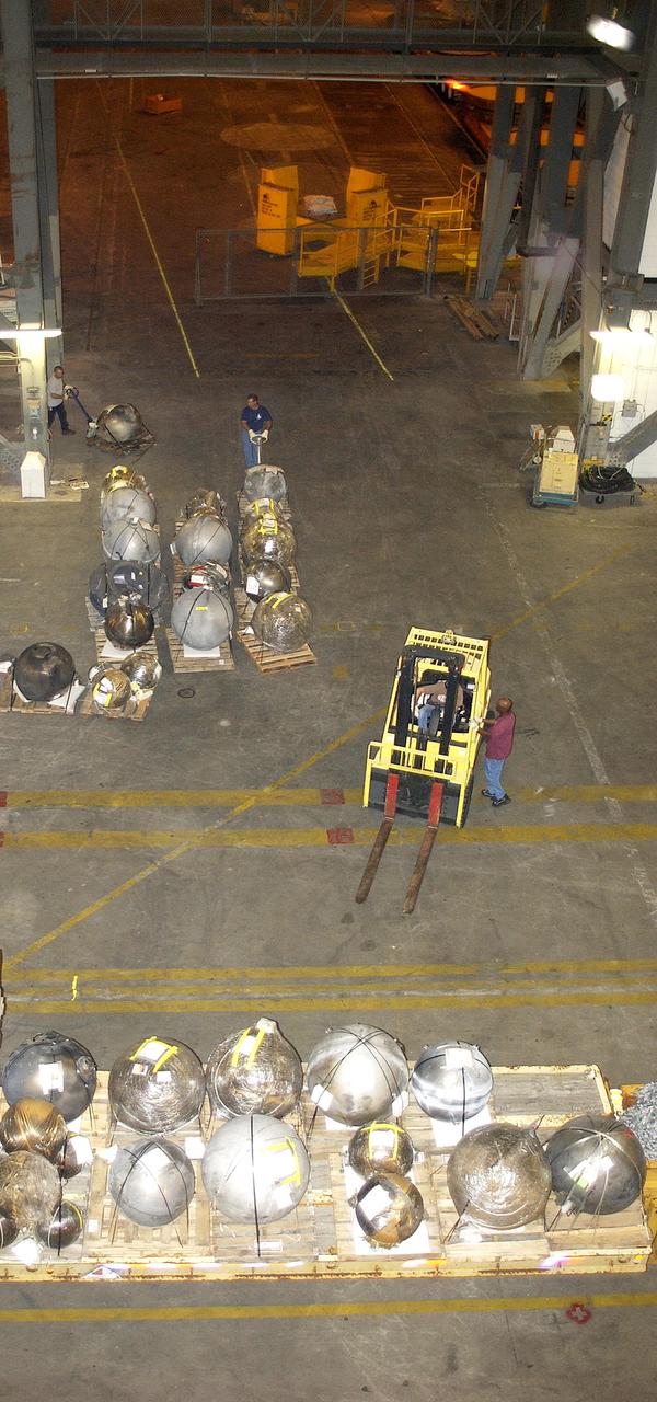 KENNEDY SPACE CENTER, FLA. -  Pieces of Columbia debris are offloaded from a flatbed truck in the transfer aisle of the Vehicle Assembly Building (VAB).  The debris is being moved from the Columbia Debris Hangar to the VAB for permanent storage.  More than 83,000 pieces of debris were shipped to KSC during search and recovery efforts in East Texas. That represents about 38 percent of the dry weight of Columbia, equaling almost 85,000 pounds.