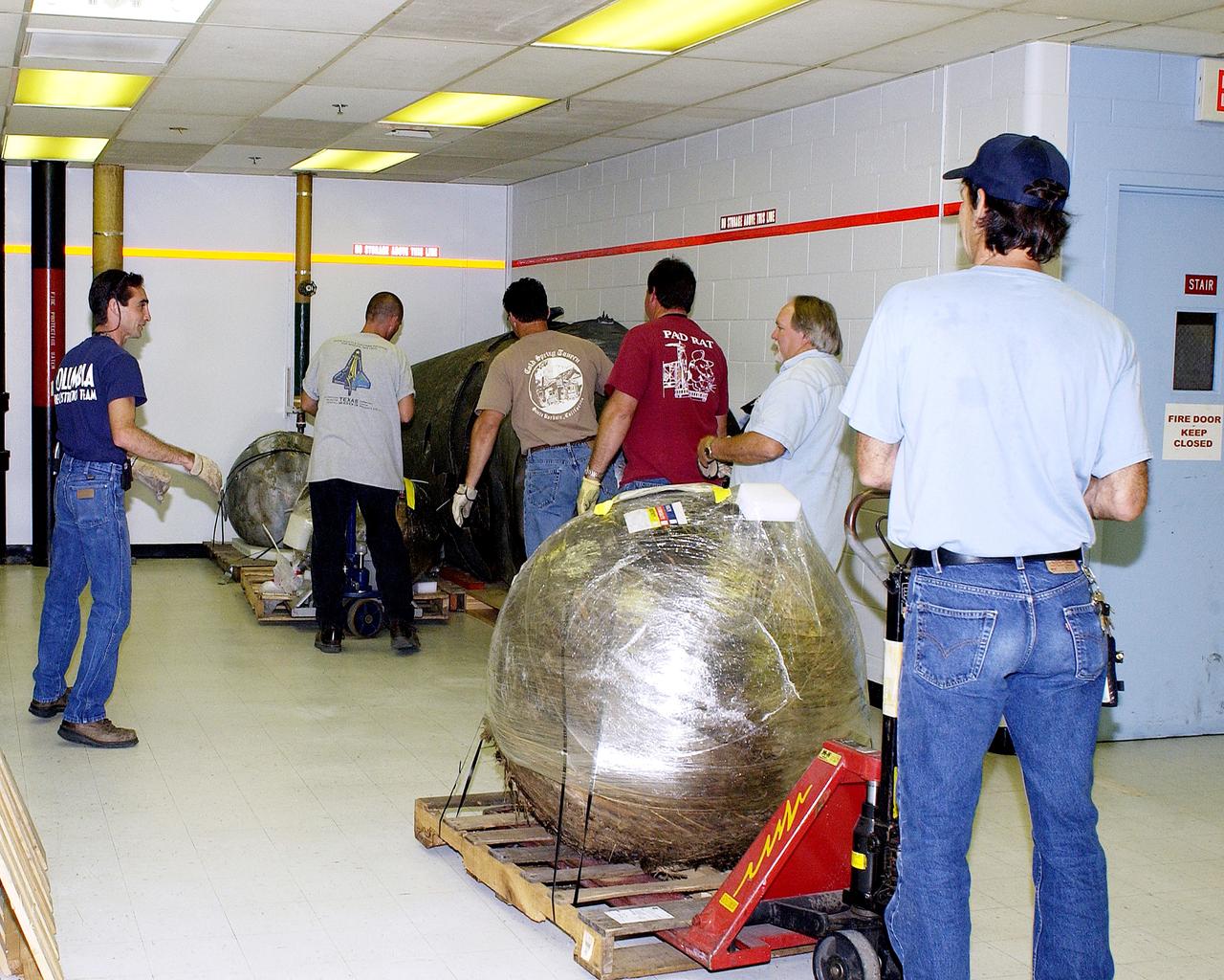 KENNEDY SPACE CENTER, FLA. -  Workers move some of the Columbia debris to its storage site in the Vehicle Assembly Building (VAB). The debris is being transferred from the Columbia Debris Hangar to the VAB for permanent storage.  More than 83,000 pieces of debris were shipped to KSC during search and recovery efforts in East Texas. That represents about 38 percent of the dry weight of Columbia, equaling almost 85,000 pounds.