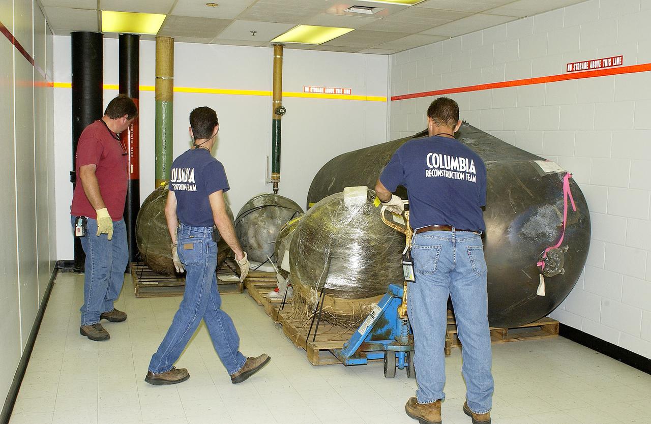 KENNEDY SPACE CENTER, FLA.  -   Workers place some of the Columbia debris moved from the Columbia Debris Hangar in its permanent storage site in the Vehicle Assembly Building.  More than 83,000  pieces of debris were shipped to KSC during search and recovery efforts in East Texas. That represents about 38 percent of the dry weight of Columbia, equaling almost 85,000 pounds.