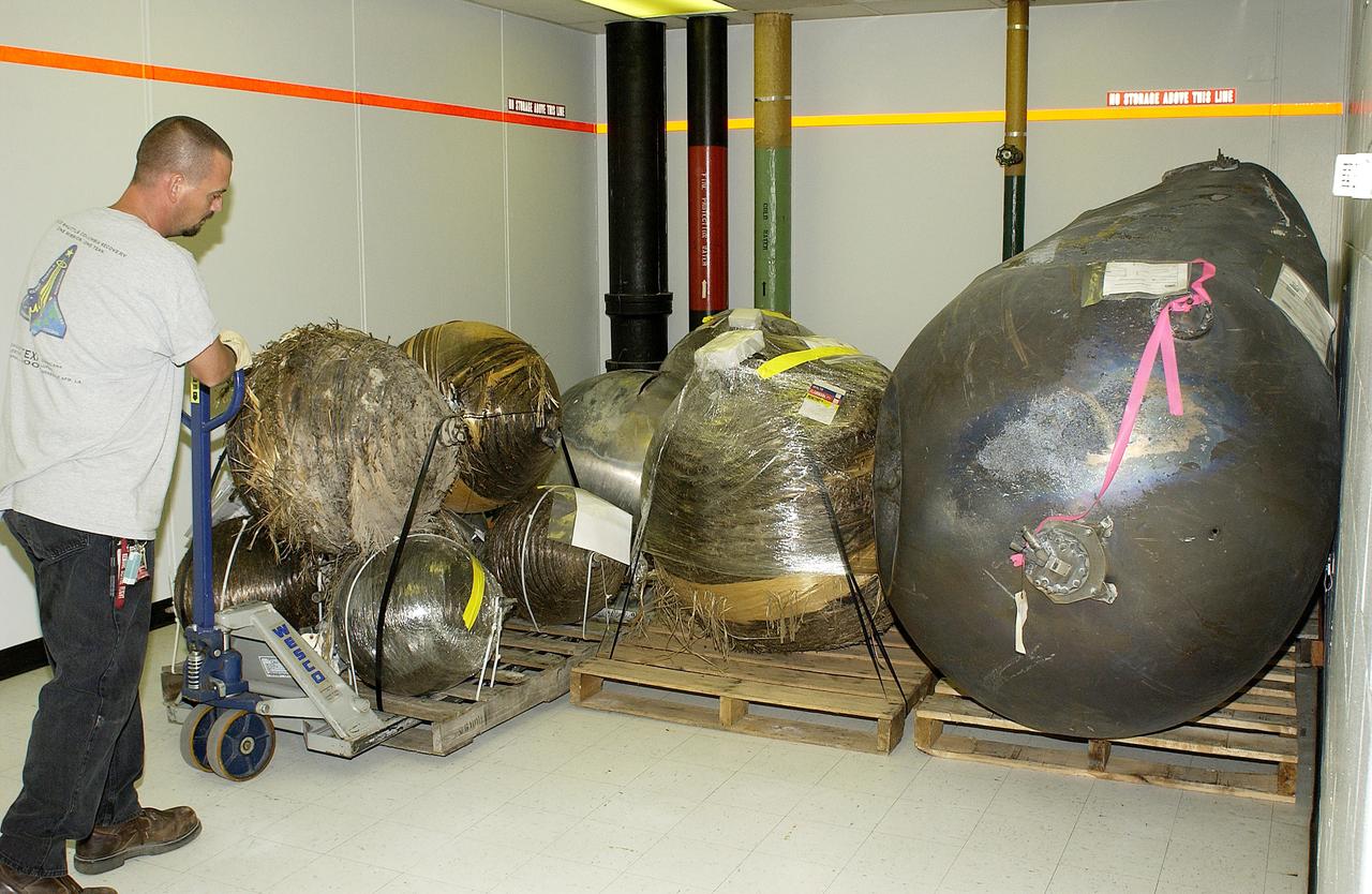 KENNEDY SPACE CENTER, FLA. -  A worker moves some of the Columbia debris to its storage site in the Vehicle Assembly Building (VAB). The debris is being transferred from the Columbia Debris Hangar to the VAB for permanent storage.  More than 83,000 pieces of debris were shipped to KSC during search and recovery efforts in East Texas. That represents about 38 percent of the dry weight of Columbia, equaling almost 85,000 pounds.