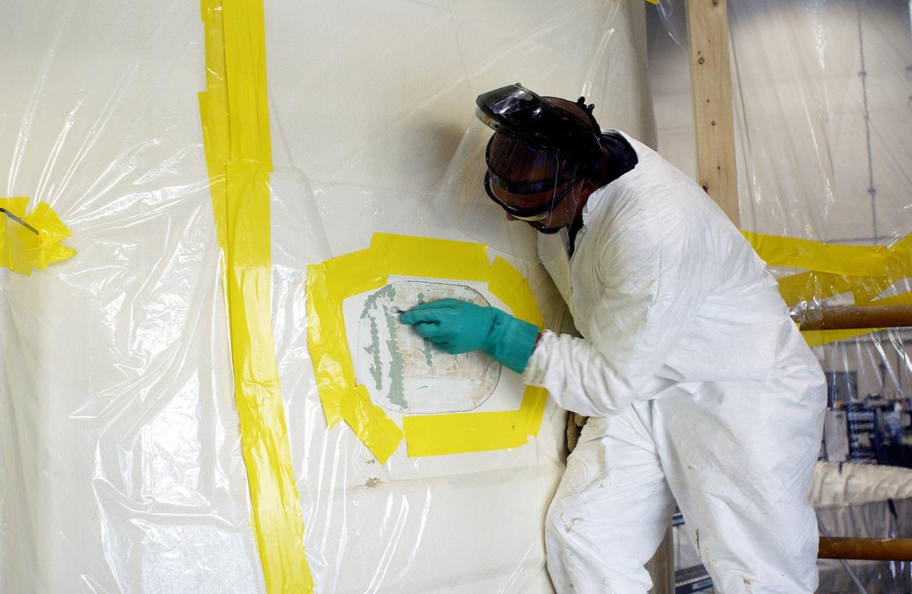 KENNEDY SPACE CENTER, FLA. - In the Solid Rocket Booster Assembly and Refurbishment Facility (ARF), Vernon Gibbs, with United Space Alliance, prepares the forward skirt of a solid rocket booster for installation of the parachute camera.  Refurbishment and subassembly of Shuttle SRB hardware - primarily the forward and aft assemblies - is carried out in the ARF.