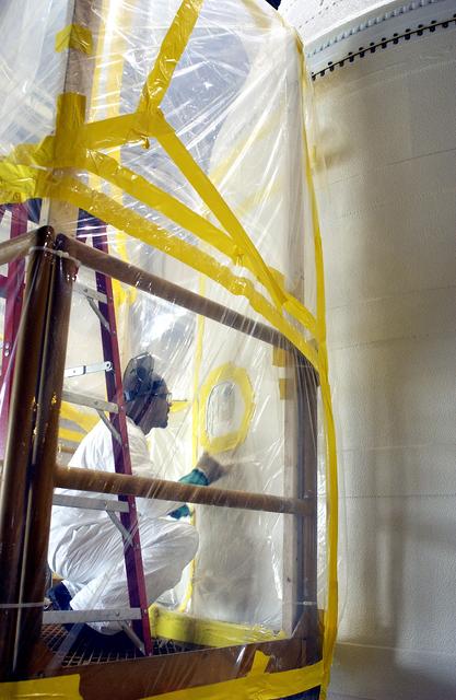 NASA image: KENNEDY SPACE CENTER, FLA. -  In the Solid Rocket Booster Assembly and Refurbishment Facility (ARF), Vernon Gibbs, with United Space Alliance, prepares the forward skirt of a solid rocket booster for installation of the parachute camera.  Refurbishment and subassembly of Shuttle SRB hardware - primarily the forward and aft assemblies - is carried out in the ARF.
