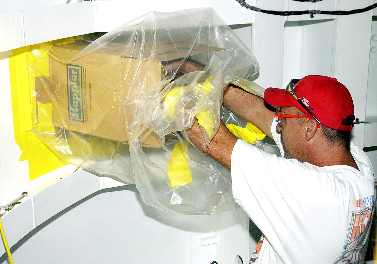 KENNEDY SPACE CENTER, FLA. - In the Solid Rocket Booster Assembly and Refurbishment Facility (ARF), Troy Krout, with United Space Alliance, works on positioning the parachute camera after installation on the solid rocket booster forward skirt.  Refurbishment and subassembly of Shuttle SRB hardware - primarily the forward and aft assemblies - is carried out in the ARF.