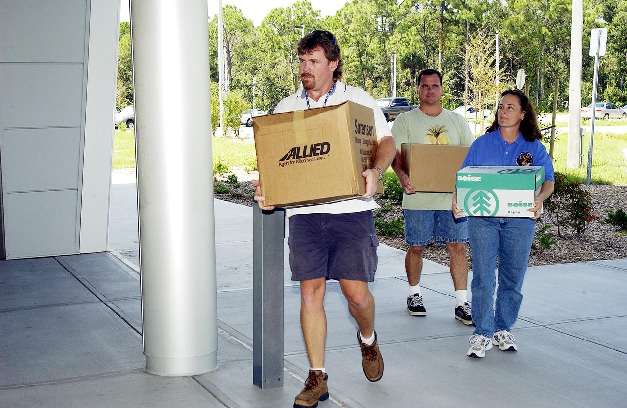 KENNEDY SPACE CENTER, FLA. -  Dynamac employees (from left) Larry Burns, Debbie Wells and Neil  Yorio carry boxes of hardware into the Space Life Sciences Lab (SLSL), formerly known as the Space Experiment Research and Processing Laboratory (SERPL).  They are transferring equipment from Hangar L. The new lab is a state-of-the-art facility being built for ISS biotechnology research. Developed as a partnership between NASA-KSC and the State of Florida, NASA’s life sciences contractor will be the primary tenant of the facility, leasing space to conduct flight experiment processing and NASA-sponsored research. About 20 percent of the facility will be available for use by Florida’s university researchers through the Florida Space Research Institute.