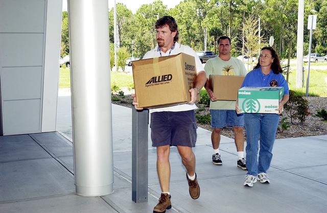NASA image: KENNEDY SPACE CENTER, FLA. -  Dynamac employees (from left) Larry Burns, Debbie Wells and Neil  Yorio carry boxes of hardware into the Space Life Sciences Lab (SLSL), formerly known as the Space Experiment Research and Processing Laboratory (SERPL).  They are transferring equipment from Hangar L. The new lab is a state-of-the-art facility being built for ISS biotechnology research. Developed as a partnership between NASA-KSC and the State of Florida, NASA’s life sciences contractor will be the primary tenant of the facility, leasing space to conduct flight experiment processing and NASA-sponsored research. About 20 percent of the facility will be available for use by Florida’s university researchers through the Florida Space Research Institute.