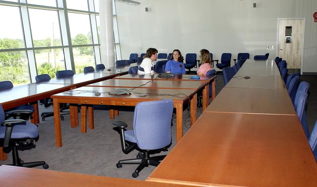NASA image: KENNEDY SPACE CENTER, FLA. - Dynamac employees (from left) Larry Burns, Debbie Wells and Michelle Crouch talk in a conference room of the Space Life Sciences Lab (SLSL), formerly known as the Space Experiment Research and Processing Laboratory (SERPL). They have been transferring equipment from Hangar L.  The new lab is a state-of-the-art facility being built for ISS biotechnology research. Developed as a partnership between NASA-KSC and the State of Florida, NASA’s life sciences contractor will be the primary tenant of the facility, leasing space to conduct flight experiment processing and NASA-sponsored research. About 20 percent of the facility will be available for use by Florida’s university researchers through the Florida Space Research Institute.