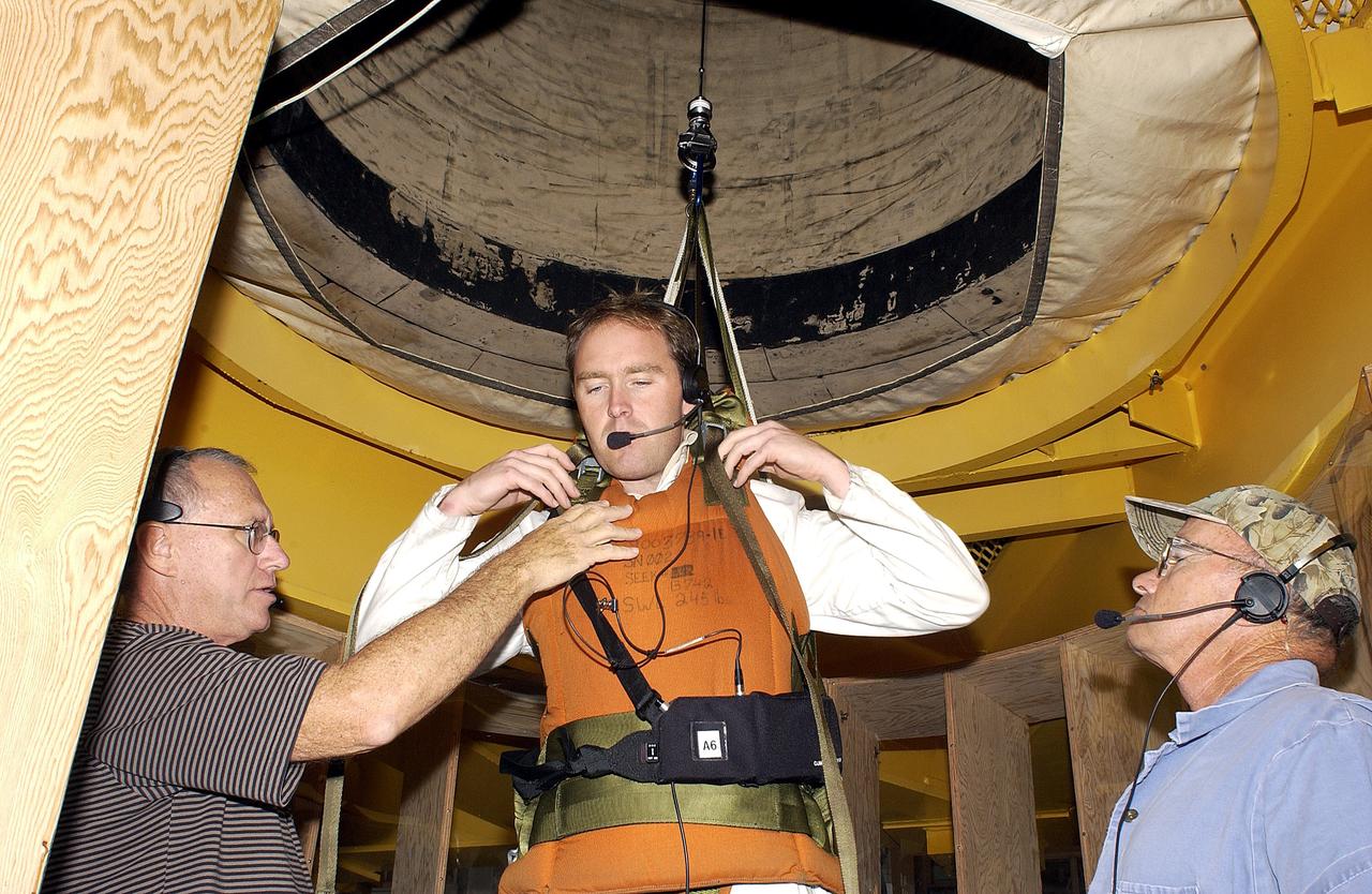 KENNEDY SPACE CENTER, FLA. -   Jeff Thon, an SRB mechanic with United Space Alliance, is fitted with a harness to test a vertical solid rocket booster propellant grain inspection technique.  Thon will be lowered inside a mockup of two segments of the SRBs.  The inspection of segments is required as part of safety analysis.