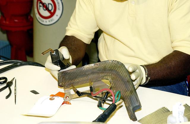 NASA image: KENNEDY SPACE CENTER, FLA. - United Space Alliance employee Anthony Simmons checks the electroweld he performed on an insulator inside a Reinforced Carbon Carbon panel.   The gray carbon composite RCC panels are attached to the leading edge of the wing of the orbiters to withstand the aerodynamic forces experienced during launch and reentry, which can reach as high as 800 pounds per square foot.  The operating range of RCC is from minus 250º F to about 3,000º F, the temperature produced by friction with the atmosphere during reentry.