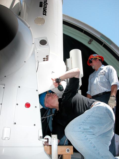 NASA image: KENNEDY SPACE CENTER, FLA. -  A worker looks at a five-meter (focal length) telescope being removed for repair.  Part of the Distant Object Attitude Measurement System (DOAMS) in Cocoa Beach, Fla., the tracking telescope provides optical support for launches from KSC and Cape Canaveral. .