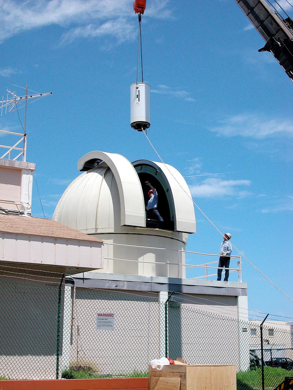 KENNEDY SPACE CENTER, FLA. - In Cocoa Beach, Fla., a new five-meter telescope is lowered toward the dome for installation.  The tracking telescope is part of the Distant Object Attitude Measurement System (DOAMS) that provides optical support for launches from KSC and Cape Canaveral.