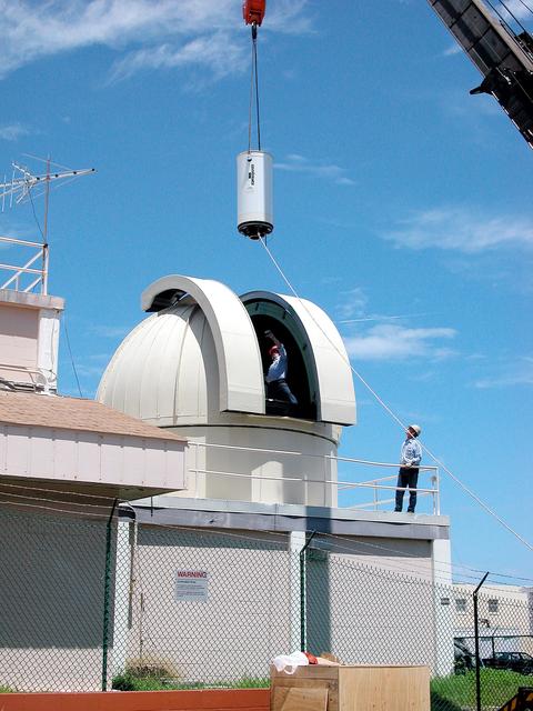 NASA image: KENNEDY SPACE CENTER, FLA. - In Cocoa Beach, Fla., a new five-meter telescope is lowered toward the dome for installation.  The tracking telescope is part of the Distant Object Attitude Measurement System (DOAMS) that provides optical support for launches from KSC and Cape Canaveral.