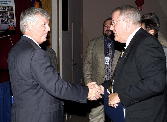 NASA image: KENNEDY SPACE CENTER, FLA. -  Center Director Jim Kennedy (left) welcomes Bill Pickavance to the podium during the CD’s first all-hands meeting with employees. Pickavance is vice president and deputy program manager, Florida operations, United Space Alliance. Also, making presentations were Dr. Woodrow Whitlow Jr., KSC deputy director, and Tim Wilson, assistant chief engineer for Shuttle. Representatives from the Shuttle program and contractor team were on hand to discuss the Columbia Accident Investigation Board report and where KSC stands in its progress toward return to flight.