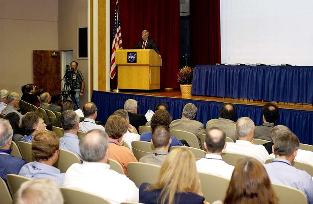 NASA image: KENNEDY SPACE CENTER, FLA. -  Center Director Jim Kennedy talks to employees during his first all-hands meeting. Making presentations were Dr. Woodrow Whitlow Jr., KSC deputy director; Tim Wilson, assistant chief engineer for Shuttle; and Bill Pickavance, vice president and deputy program manager, Florida operations, United Space Alliance..  Representatives from the Shuttle program and contractor team were on hand to discuss the Columbia Accident Investigation Board report and where KSC stands in its progress toward return to flight.