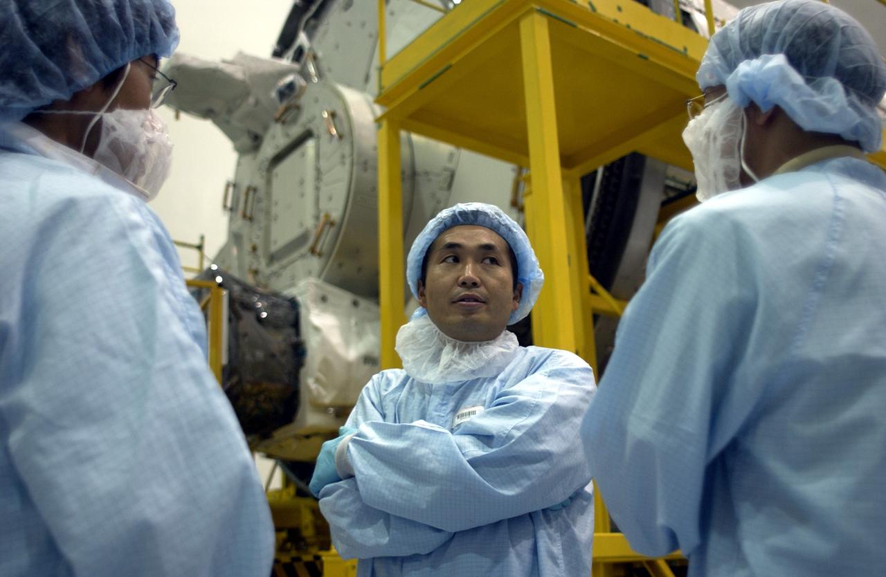 KENNEDY SPACE CENTER, FLA. -  In the Space Station Processing Facility, Japanese astronaut Koichi Wakata,  dressed in protective clothing, talks with workers before entering the Pressurized Module, or PM, behind him.  Part of the Japanese Experiment Module (JEM), the PM provides a shirt-sleeve environment in which astronauts on the International Space Station can conduct microgravity experiments. There are a total of 23 racks, including 10 experiment racks, inside the PM providing a power supply, communications, air conditioning, hardware cooling, water control and experiment support functions.