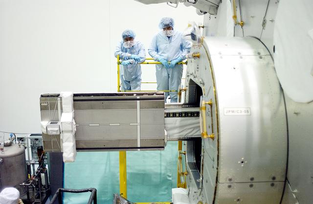 NASA image: KENNEDY SPACE CENTER, FLA. -  In the Space Station Processing Facility, Japanese astronaut Koichi Wakata (top left) and technicians watch as a tray is extended from inside the Pressurized Module, or PM, part of the Japanese Experiment Module (JEM).   The PM provides a shirt-sleeve environment in which astronauts on the International Space Station can conduct microgravity experiments. There are a total of 23 racks, including 10 experiment racks, inside the PM providing a power supply, communications, air conditioning, hardware cooling, water control and experiment support functions.