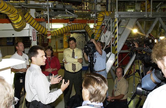NASA image: KENNEDY SPACE CENTER, FLA. -   NASA Vehicle Manager Scott Thurston (hands extended) talks to the media in the Orbiter Processing Facility.  The media was invited to see the orbiter Atlantis as it is being prepared for Return to Flight.  Both local and national reporters representing print and TV networks were able to see work in progress on Atlantis, including the reinstallation of the Reinforced Carbon-Carbon panels on the orbiter’s wing leading edge; wiring inspections; and checks of the engines in the Orbital Maneuvering System.