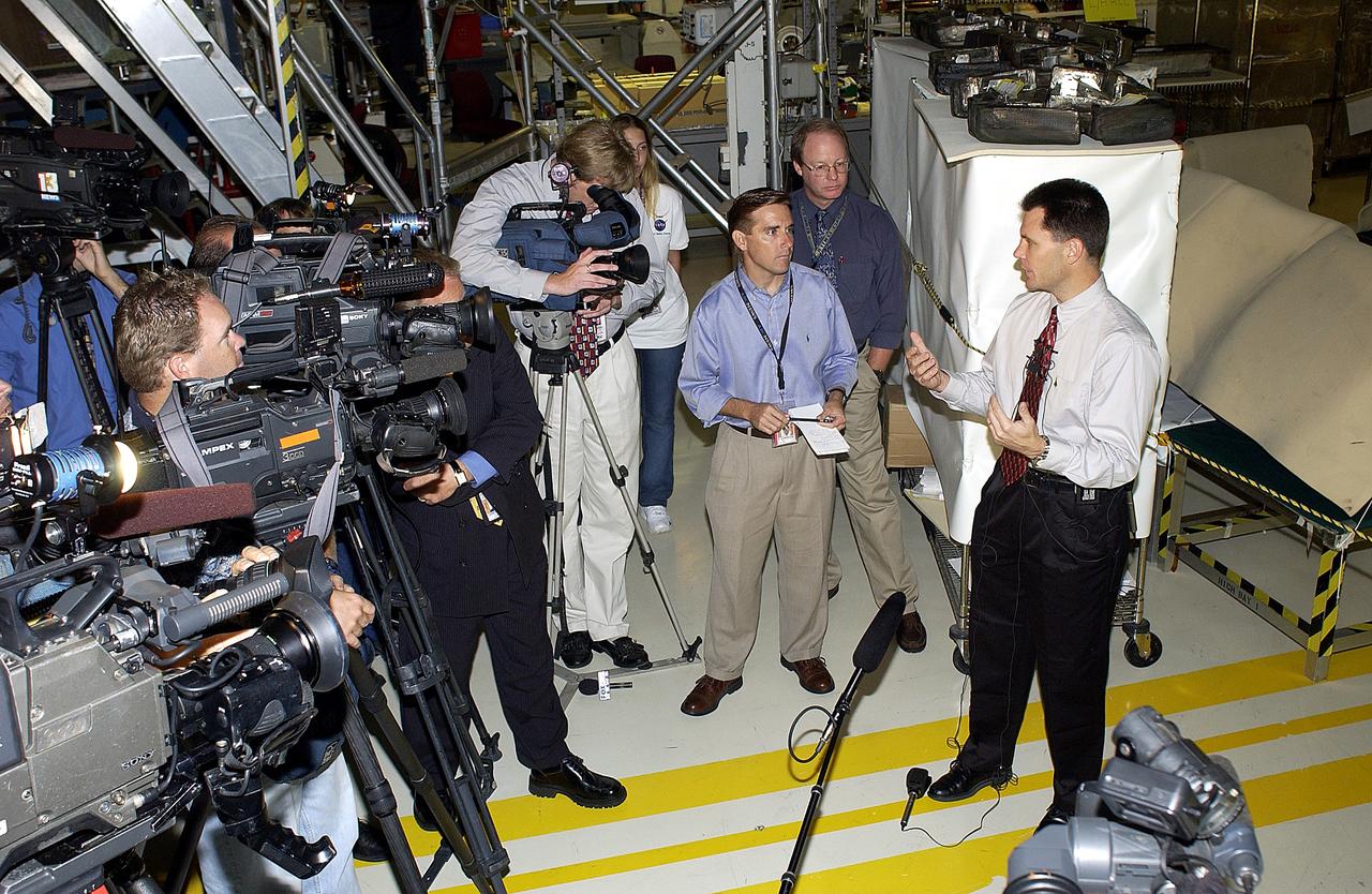 KENNEDY SPACE CENTER, FLA. -   NASA Vehicle Manager Scott Thurston (right)  talks to the media in the Orbiter Processing Facility.  The media was invited to see the orbiter Atlantis as it is being prepared for Return to Flight.  Both local and national reporters representing print and TV networks were able to see work in progress on Atlantis, including the reinstallation of the Reinforced Carbon-Carbon panels on the orbiter’s wing leading edge; wiring inspections; and checks of the engines in the Orbital Maneuvering System.  will be available to discuss the work and answer questions.
