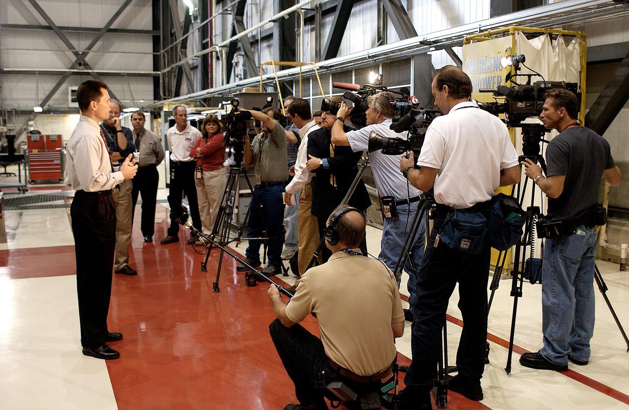 KENNEDY SPACE CENTER, FLA. - NASA Vehicle Manager Scott Thurston (left) talks to a phalanx of media in the Orbiter Processing Facility.  The media was invited to see the orbiter Atlantis as it is being prepared for Return to Flight.  Both local and national reporters representing print and TV networks were able to see work in progress on Atlantis, including the reinstallation of the Reinforced Carbon-Carbon panels on the orbiter’s wing leading edge; wiring inspections; and checks of the engines in the Orbital Maneuvering System.