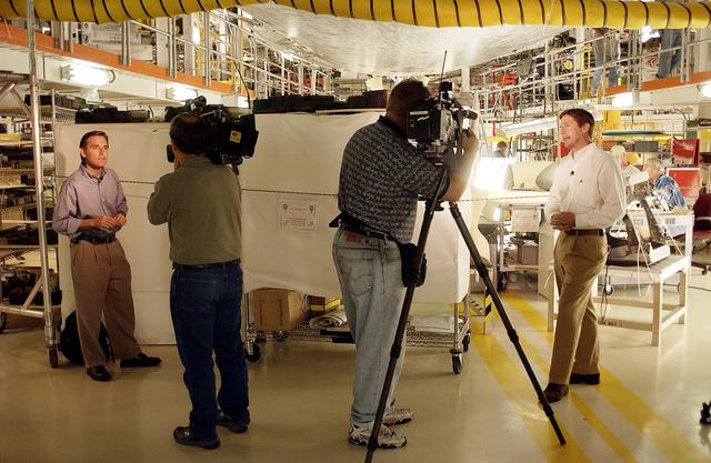 NASA image: KENNEDY SPACE CENTER, FLA. - Local Central Florida television reporters Phil Robertson (left), with WFTV, and Dan Billow (right), with WESH, tape commentaries after a media tour of the Orbiter Processing Facility.  The media was invited to see the orbiter Atlantis as it is being prepared for Return to Flight.  Both local and national reporters representing print and TV networks were able to see work in progress on Atlantis, including the reinstallation of the Reinforced Carbon-Carbon panels on the orbiter’s wing leading edge; wiring inspections; and checks of the engines in the Orbital Maneuvering System.