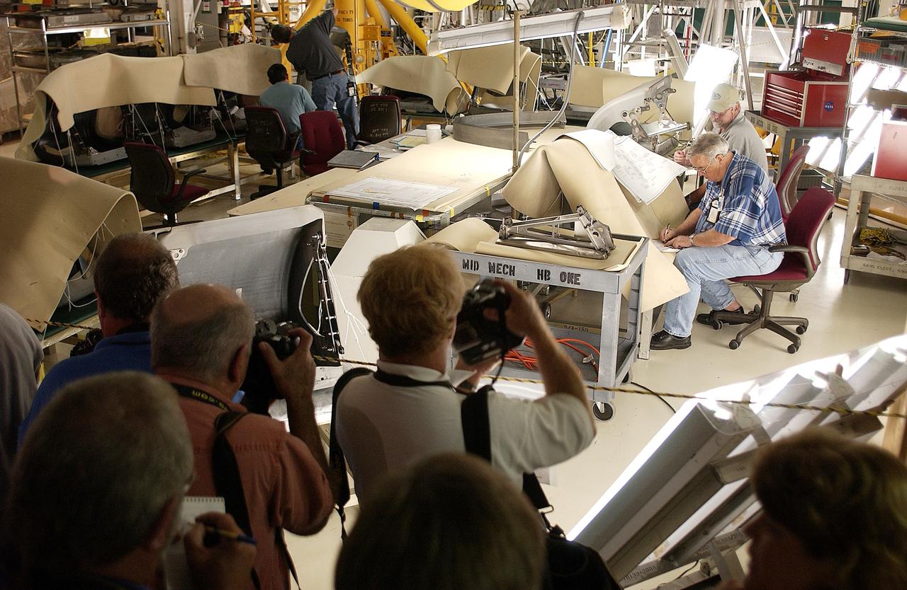 KENNEDY SPACE CENTER, FLA. -  In the Orbiter Processing Facility, the media record workers on the job preparing the orbiter Atlantis for Return to Flight. Both local and national reporters representing print and TV networks were invited to see work in progress on Atlantis, including the reinstallation of the Reinforced Carbon-Carbon panels on the orbiter’s wing leading edge; wiring inspections; and checks of the engines in the Orbital Maneuvering System.