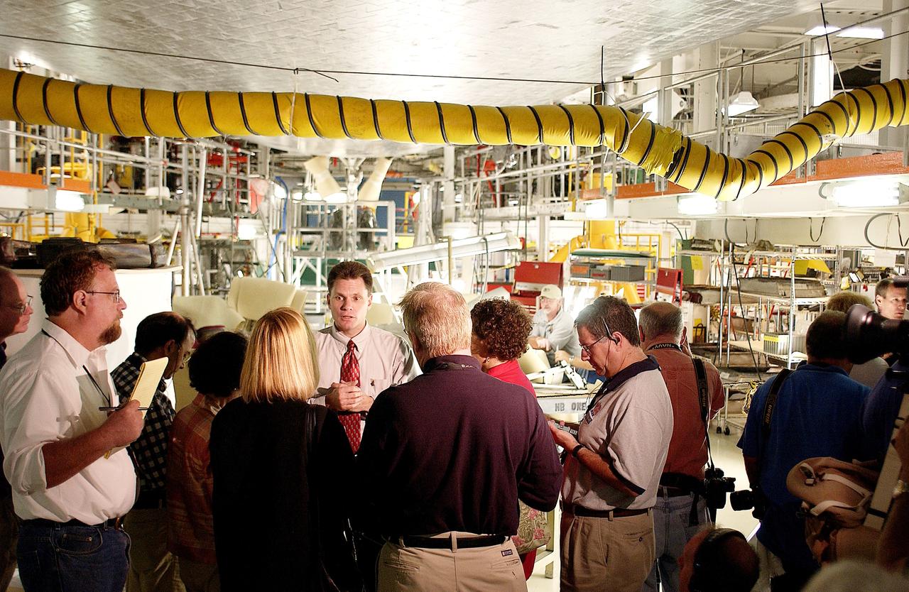 KENNEDY SPACE CENTER, FLA. -  NASA Vehicle Manager Scott Thurston (facing camera) talks to the media in the Orbiter Processing Facility.  The media was invited to see the orbiter Atlantis as it is being prepared for Return to Flight.  Both local and national reporters representing print and TV networks were able to see work in progress on Atlantis, including the reinstallation of the Reinforced Carbon-Carbon panels on the orbiter’s wing leading edge; wiring inspections; and checks of the engines in the Orbital Maneuvering System.