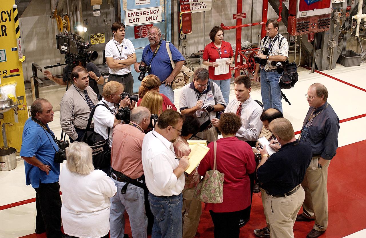 KENNEDY SPACE CENTER, FLA. -   The media gather around NASA Vehicle Manager Scott Thurston (white shirt, right) who talks about some of the work being done on the orbiter Atlantis as it is being prepared for Return to Flight in the Orbiter Processing Facility.   Both local and national reporters representing print and TV networks were able to see work in progress on Atlantis, including the reinstallation of the Reinforced Carbon-Carbon panels on the orbiter’s wing leading edge; wiring inspections; and checks of the engines in the Orbital Maneuvering System.