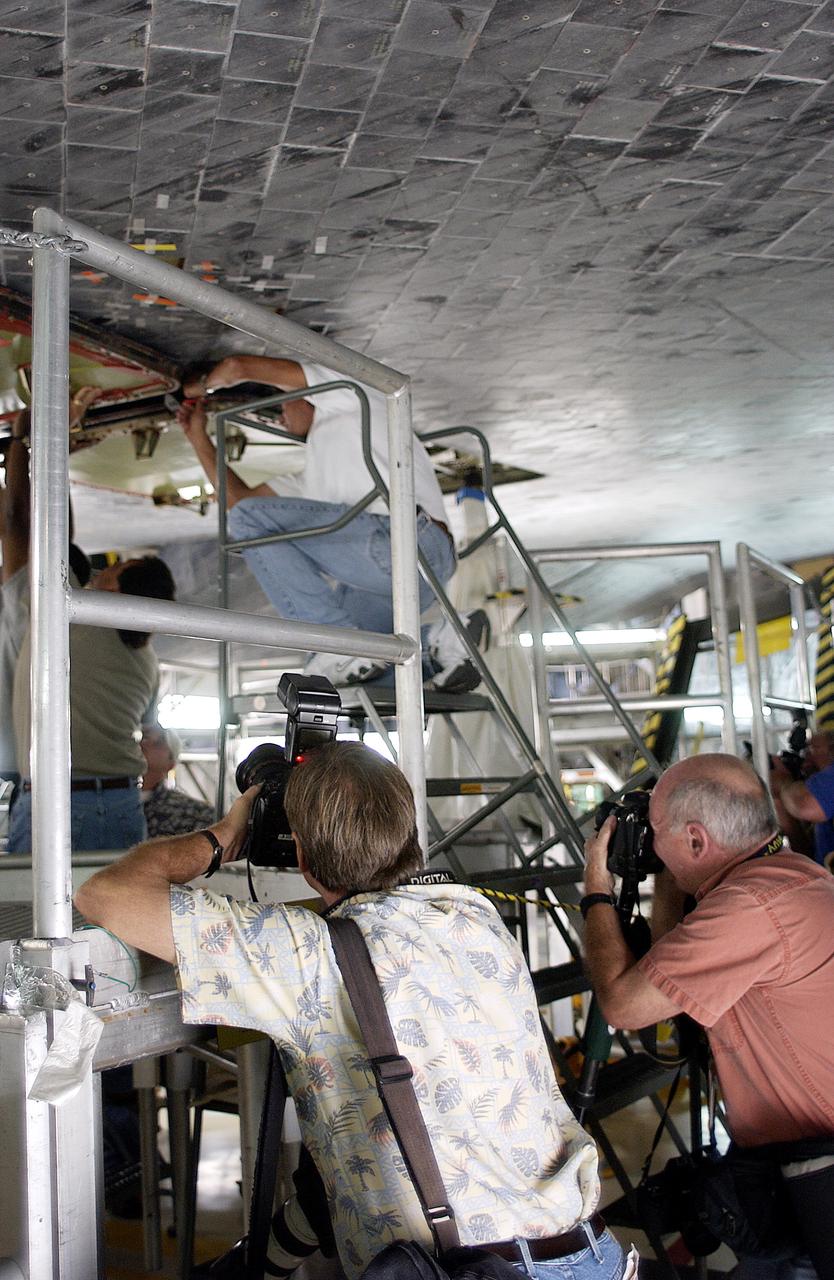 KENNEDY SPACE CENTER, FLA. -   In the Orbiter Processing Facility,  the media photograph work being done on the tiles on the orbiter Atlantis as it is being prepared for Return to Flight in the Orbiter Processing Facility.   Both local and national reporters representing print and TV networks were able to see work in progress on Atlantis, including the reinstallation of the Reinforced Carbon-Carbon panels on the orbiter’s wing leading edge; wiring inspections; and checks of the engines in the Orbital Maneuvering System.