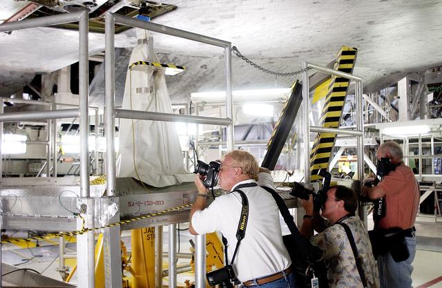 NASA image: KENNEDY SPACE CENTER, FLA. -  In the Orbiter Processing Facility,  the media photograph work being done on the tiles on the orbiter Atlantis as it is being prepared for Return to Flight in the Orbiter Processing Facility.   Both local and national reporters representing print and TV networks were able to see work in progress on Atlantis, including the reinstallation of the Reinforced Carbon-Carbon panels on the orbiter’s wing leading edge; wiring inspections; and checks of the engines in the Orbital Maneuvering System.