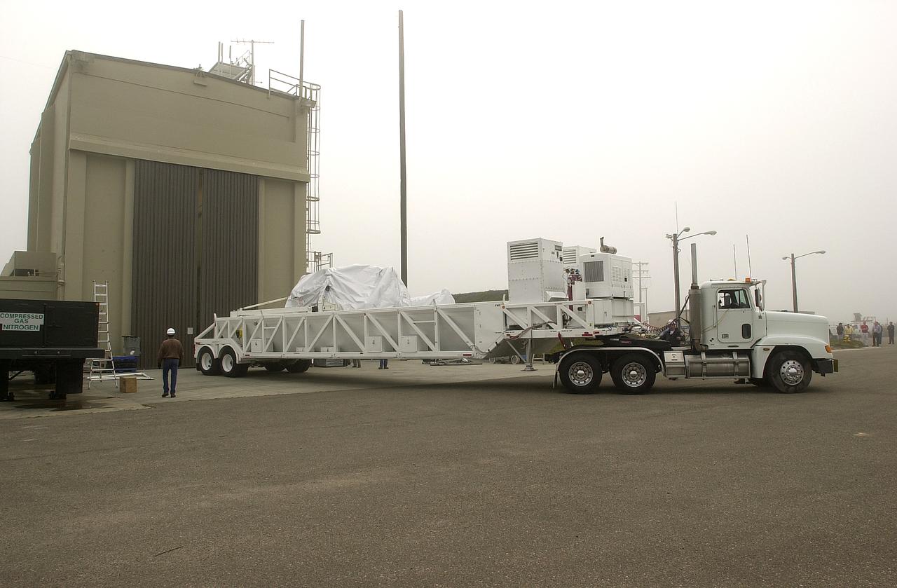 A transporter carrying the Gravity Probe B experiment backs into the spacecraft processing facility on North Vandenberg Air Force Base. Gravity Probe B will launch a payload of four gyroscopes into low-Earth polar orbit to test two extraordinary predictions of Albert Einstein’s general theory of relativity: the geodetic effect (how space and time are warped by the presence of the Earth) and frame dragging (how Earth’s rotation drags space and time around with it). Once in orbit, for 18 months each gyroscope’s spin axis will be monitored as it travels through local spacetime, observing and measuring these effects. The experiment was developed by Stanford University, Lockheed Martin and NASA’s Marshall Space Flight Center.