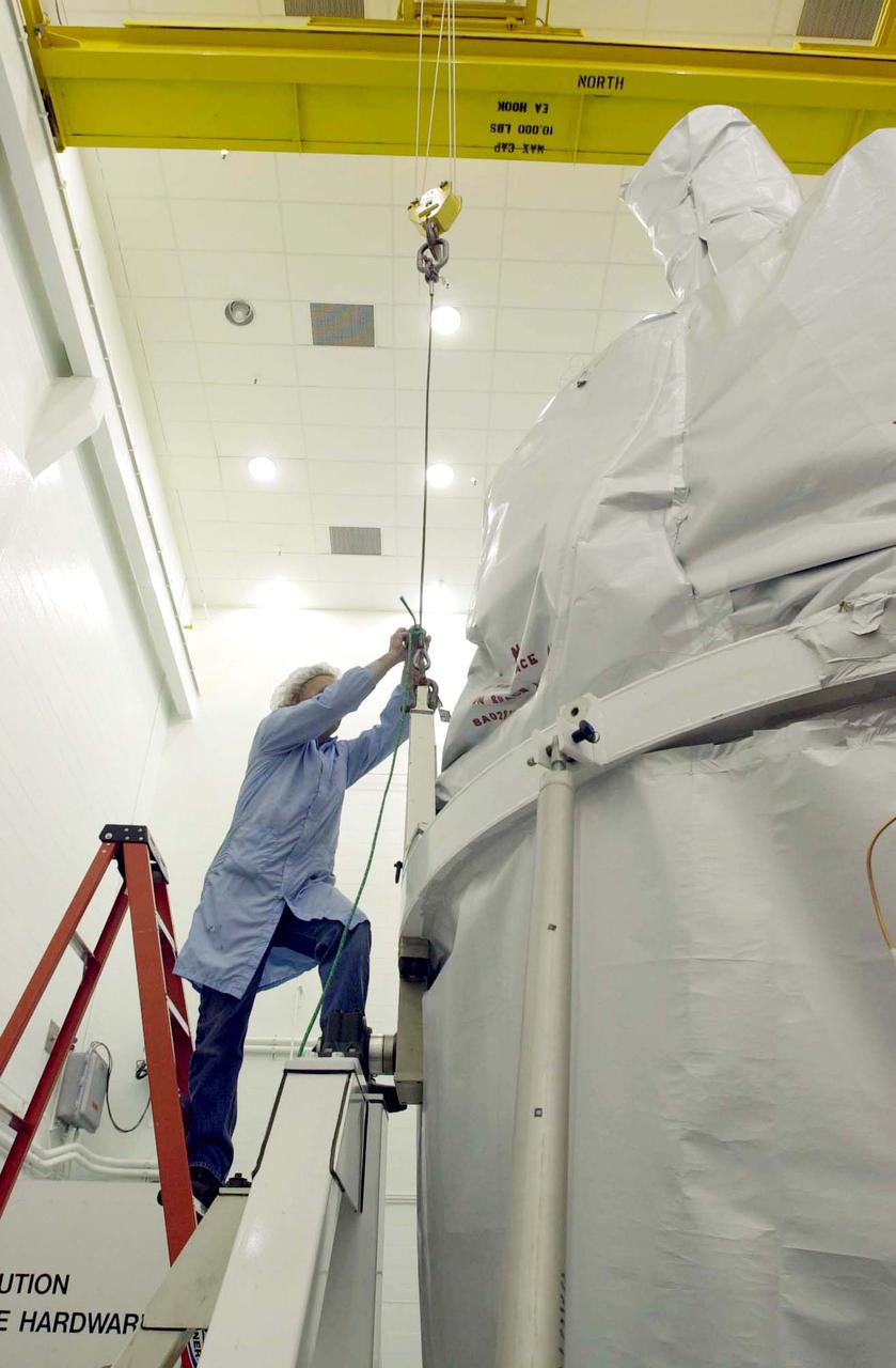 In the spacecraft processing facility on North Vandenberg Air Force Base, workers prepare to remove the soft shipping cover from the Gravity Probe B experiment. Immediate processing includes setting up mechanical and electrical ground support equipment, making necessary connections and conditioning the spacecraft battery. The Gravity Probe B will launch a payload of four gyroscopes into low-Earth polar orbit to test two extraordinary predictions of Albert Einstein’s general theory of relativity: the geodetic effect (how space and time are warped by the presence of the Earth) and frame dragging (how Earth’s rotation drags space and time around with it). Once in orbit, for 18 months each gyroscope’s spin axis will be monitored as it travels through local spacetime, observing and measuring these effects. The experiment was developed by Stanford University, Lockheed Martin and NASA’s Marshall Space Flight Center.