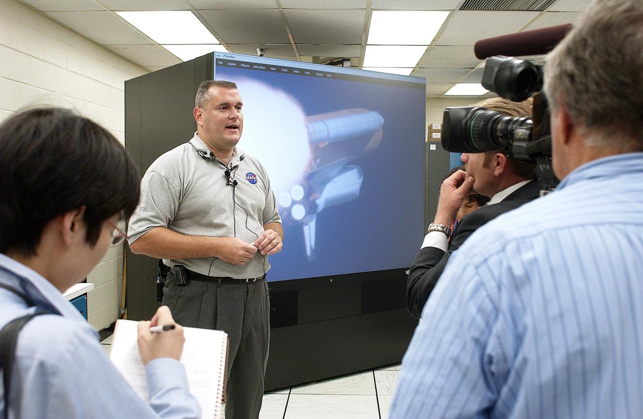 In the Image Analysis Facility in the Vehicle Assembly Building, Armando Oliu (second from left), lead of the KSC Ice and Debris Team, answers questions from news media representatives on the improved tracking cameras and long-range optical tracking systems that will be used to capture ascent imagery during the return to flight of the Space Shuttle. The press opportunity also includes tours of the launch pad perimeter camera site at Launch Complex 39B and two Playalinda Beach optical tracking sites at the Cape Canaveral National Seashore and the Merritt Island National Refuge.