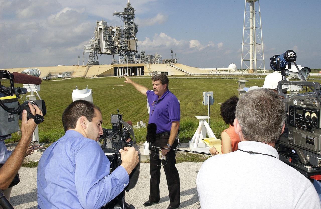 At the launch pad perimeter camera site at Launch Complex 39B, Robert Page (pointing), chair of the NASA Intercenter Photo Working Group, briefs news media representatives on the improved tracking cameras that will be used to capture ascent imagery during the return to flight of the Space Shuttle. The press opportunity also includes tours of the Image Analysis Facility in the Vehicle Assembly Building and two Playalinda Beach optical tracking sites at the Cape Canaveral National Seashore and the Merritt Island National Refuge.