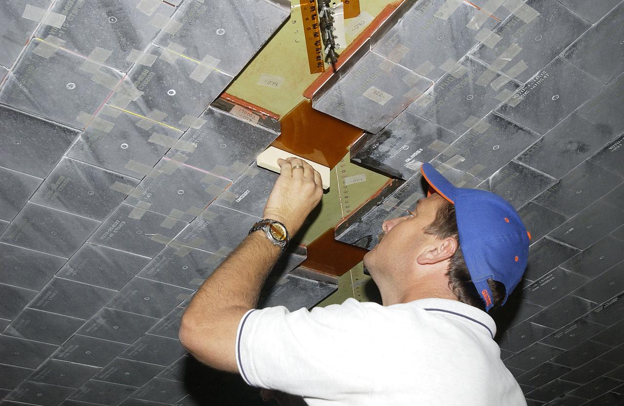 In the Orbiter Processing Facility, Rick Cady, with United Space Alliance, removes a tile from Endeavour. Tile check is part of routine maintenance and return to flight activities on the orbiter fleet. 