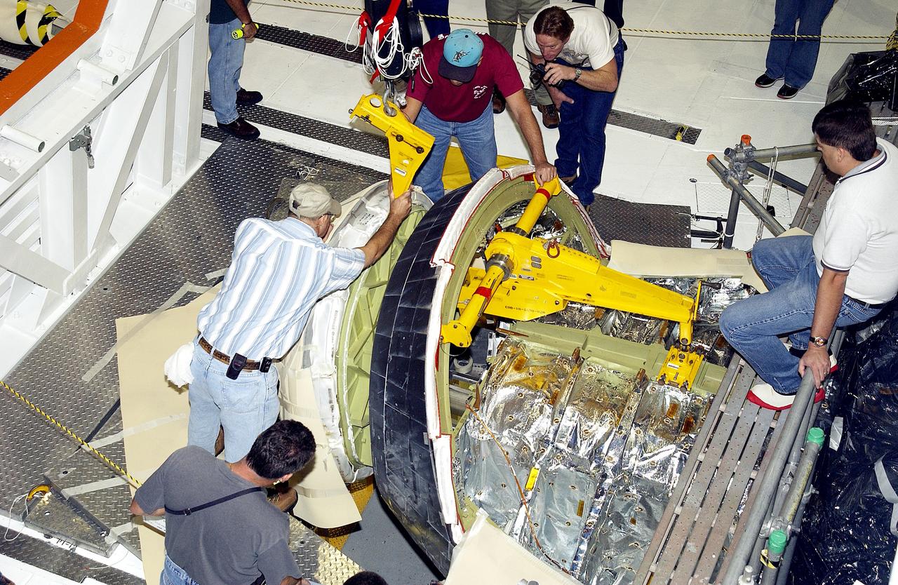 KENNEDY SPACE CENTER, FLA. - In the Orbiter Processing Facility, workers remove the nose cone of the orbiter Atlantis for routine inspection. The nose cap is made of reinforced carbon-carbon (RCC), which has an operating range of minus 250° F to about 3,000° F.