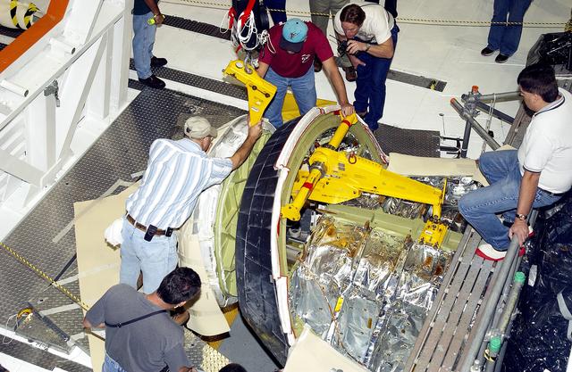 NASA image: KENNEDY SPACE CENTER, FLA. - In the Orbiter Processing Facility, workers remove the nose cone of the orbiter Atlantis for routine inspection. The nose cap is made of reinforced carbon-carbon (RCC), which has an operating range of minus 250° F to about 3,000° F.