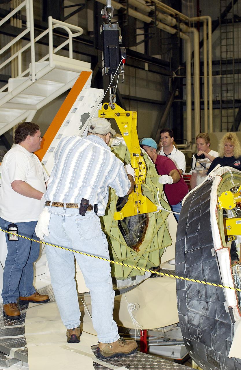 KENNEDY SPACE CENTER, FLA. - In the Orbiter Processing Facility, workers secure the nose cap of the orbiter Atlantis for its transfer to a stand.  The cap was removed for routine inspection. The nose cap is made of reinforced carbon-carbon (RCC), which has an operating range of minus 250° F to about 3,000° F.