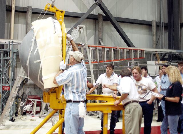NASA image: KENNEDY SPACE CENTER, FLA. -  In the Orbiter Processing Facility, workers secure the nose cap of the orbiter Atlantis on a stand.   The cap was removed from the orbiter for routine inspection. The nose cap is made of reinforced carbon-carbon (RCC), which has an operating range of minus 250° F to about 3,000° F.