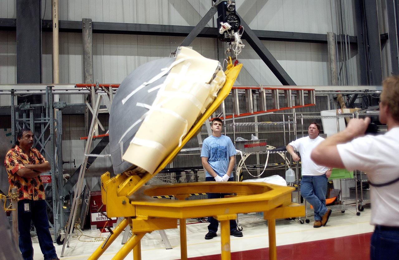 KENNEDY SPACE CENTER, FLA. - In the Orbiter Processing Facility, the nose cap of the orbiter Atlantis is shifted to a horizontal position on a stand.  The cap was removed from the orbiter for routine inspection. The nose cap is made of reinforced carbon-carbon (RCC), which has an operating range of minus 250° F to about 3,000° F.