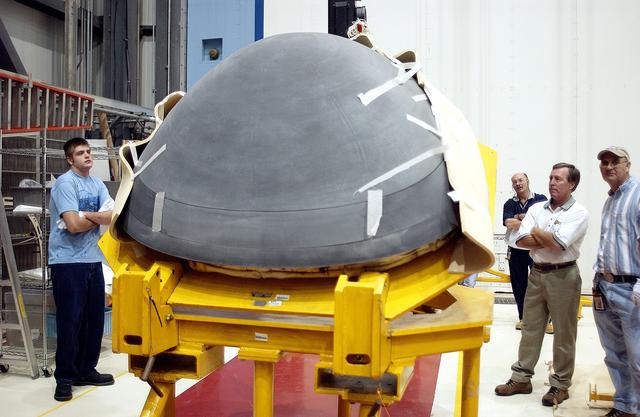 NASA image: KENNEDY SPACE CENTER, FLA. - In the Orbiter Processing Facility, workers watch as the nose cap of the orbiter Atlantis is shifted to a horizontal position on a stand.  The cap was removed from the orbiter for routine inspection. The nose cap is made of reinforced carbon-carbon (RCC), which has an operating range of minus 250° F to about 3,000° F.