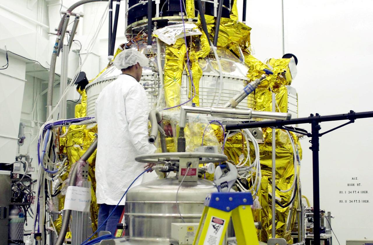 VANDENBERG AFB, CALIF. -   A worker in the spacecraft processing facility on North Vandenberg Air Force Base checks the Gravity Probe B experiment during prelaunch testing.  The Gravity Probe B will launch a payload of four gyroscopes into low-Earth polar orbit to test two extraordinary predictions of Albert Einstein’s general theory of relativity: the geodetic effect (how space and time are warped by the presence of the Earth) and frame dragging (how Earth’s rotation drags space and time around with it). Once in orbit, for 18 months each gyroscope’s spin axis will be monitored as it travels through local spacetime, observing and measuring these effects.  The experiment was developed by Stanford University, Lockheed Martin and NASA’s Marshall Space Flight Center.   The targeted launch date is Dec. 6, 2003.