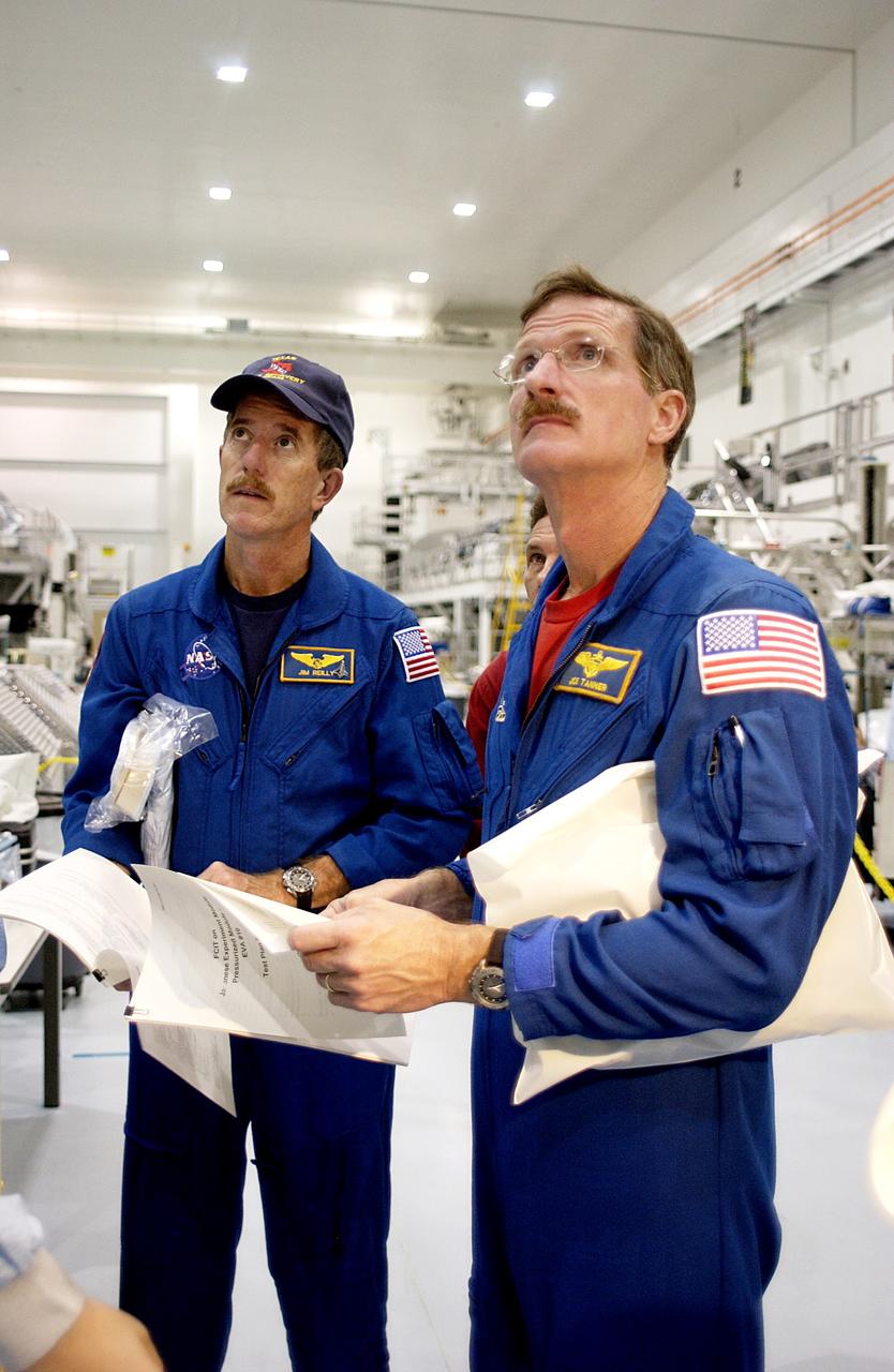 KENNEDY SPACE CENTER, FLA. - In the Space Station Processing Facility, STS-117 Mission Specialist James Reilly (left) and STS-115 Mission Specialist Joseph Tanner (right) look over the Japanese Experiment Module (JEM).  Equipment familiarization is a routine part of astronaut training and launch preparations.