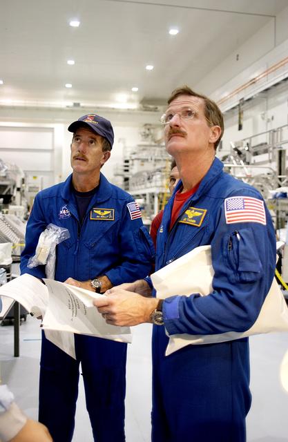 KENNEDY SPACE CENTER, FLA. - In the Space Station Processing Facility, STS-117 Mission Specialist James Reilly (left) and STS-115 Mission Specialist Joseph Tanner (right) look over the Japanese Experiment Module (JEM).  Equipment familiarization is a routine part of astronaut training and launch preparations.